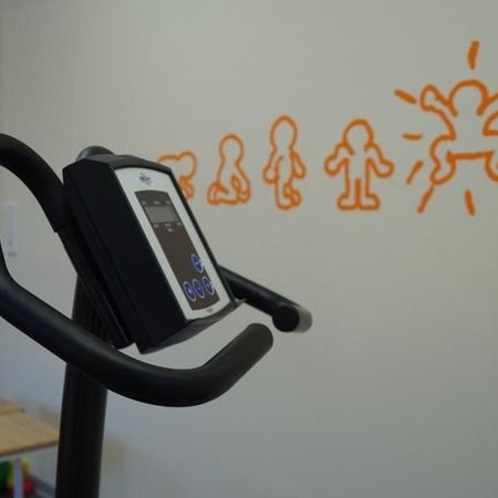 Die Anzeigetafel eines elliptischen Geräts mit orangefarbenem Strichmännchen im Hintergrund